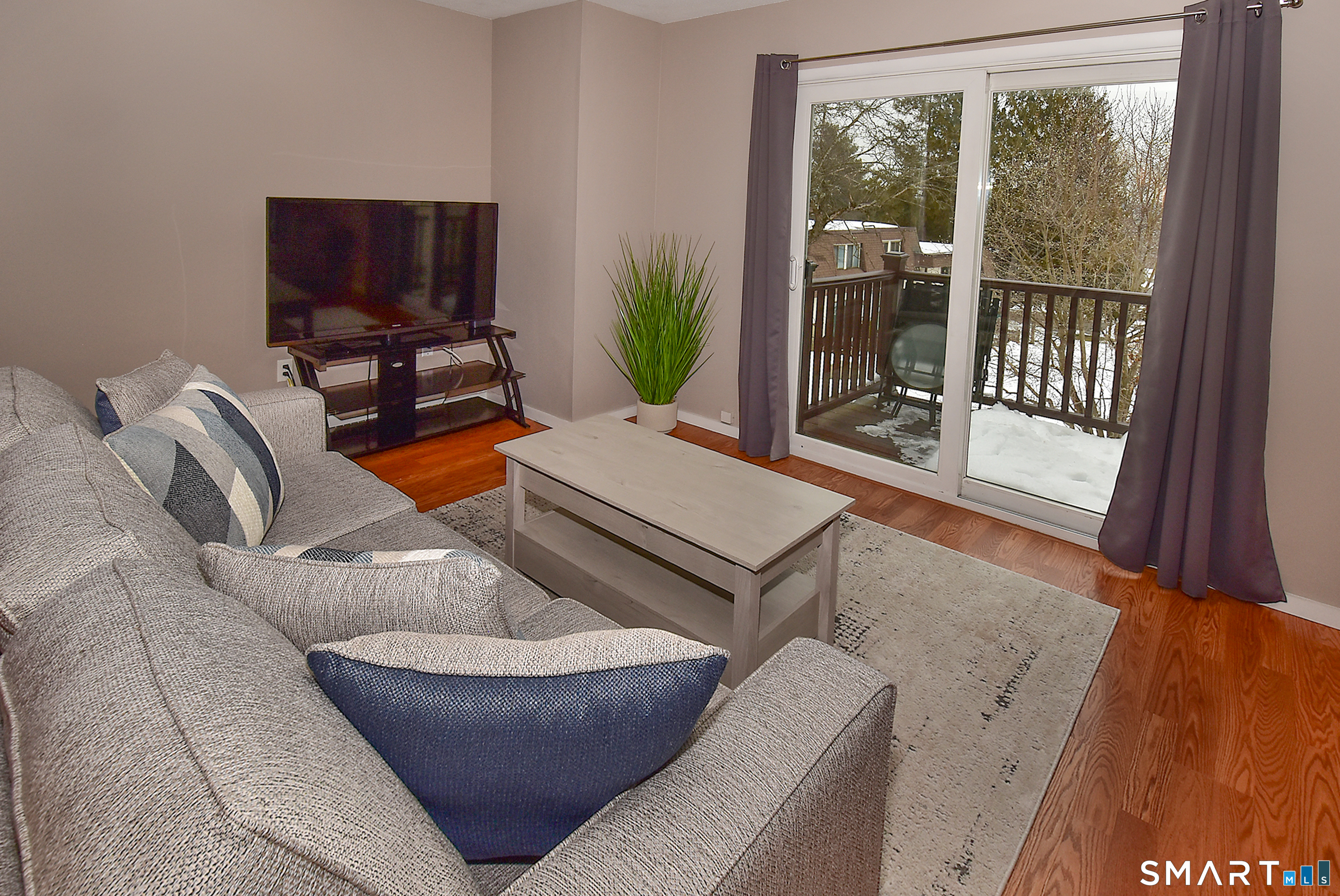 24 Pebblestone Circle, Unit 24 Suffield, CT 06078 - Photo 4 of 25 a living room with furniture a floor to ceiling window and a flat screen tv