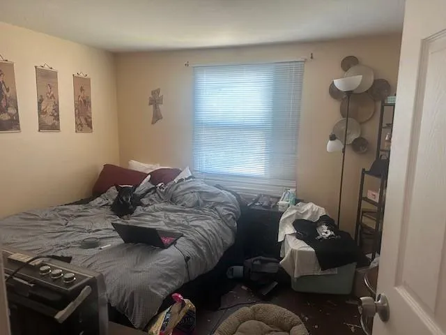 a bed sitting in a bedroom next to a window