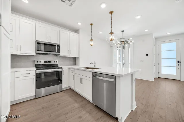 a kitchen with white cabinets and stainless steel appliances
