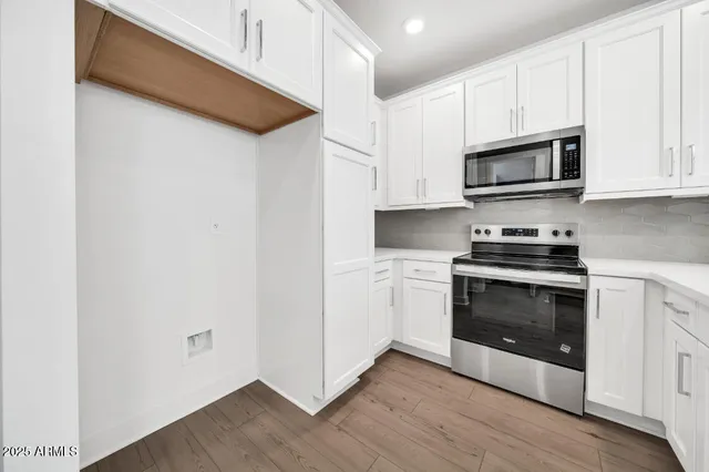 a kitchen with granite countertop white cabinets and stainless steel appliances