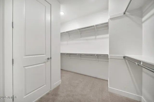 an empty room with ceiling fan and windows