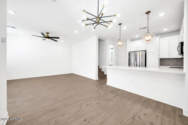 a kitchen with stainless steel appliances a refrigerator stove and white cabinets