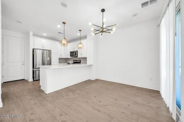 a kitchen with stainless steel appliances a refrigerator sink and microwave