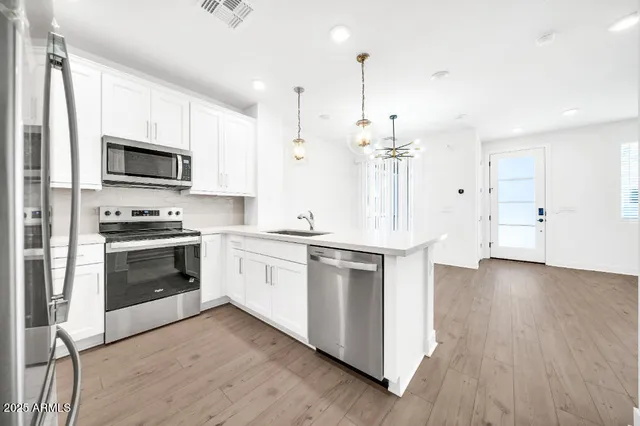 a view of a kitchen with a sink stainless steel appliances and cabinets