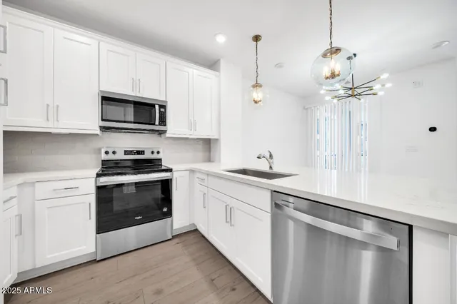 a large kitchen with stainless steel appliances a large counter top oven a sink and a refrigerator