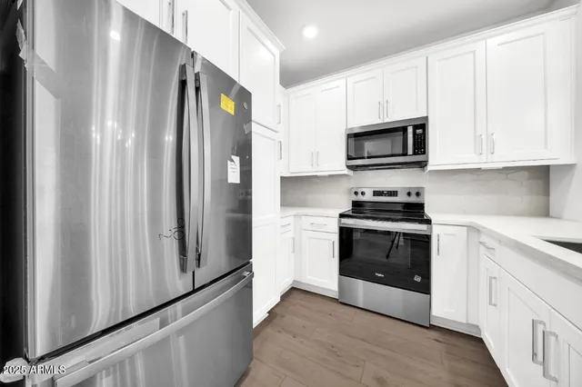 a view of kitchen with granite countertop cabinets and refrigerator