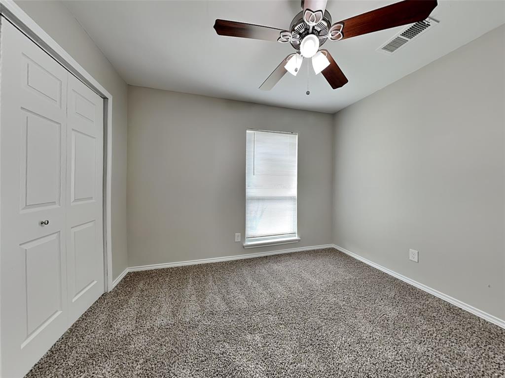 7621 Pebble Beach Drive Rowlett, TX 75088 - Photo 15 of 20 an empty room with a chandelier fan and windows
