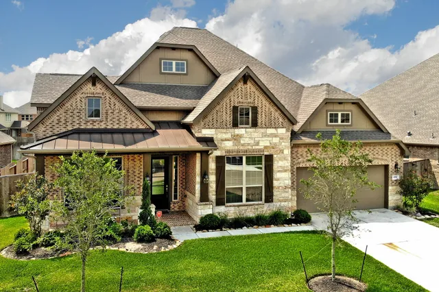 a front view of a house with a yard and potted plants