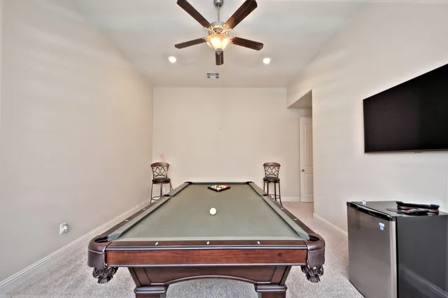 a room with pool table and a ceiling fan