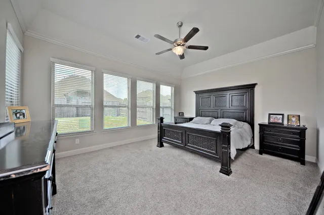 a spacious bedroom with a bed and a chandelier