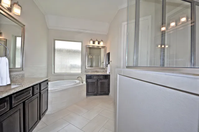 a bathroom with a tub sink and mirror