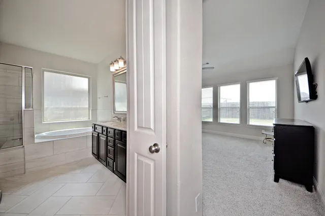 a view of a hallway with windows and chandelier