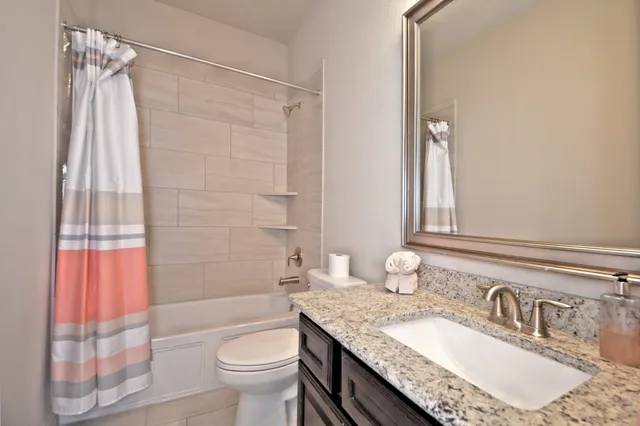 a bathroom with a granite countertop sink toilet and shower