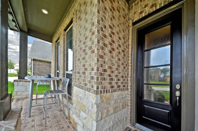 a porch with a bench next to a yard