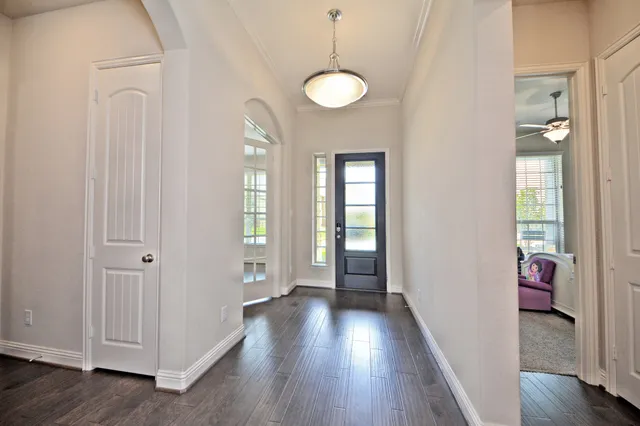 a view of a hallway with wooden floor and stairs