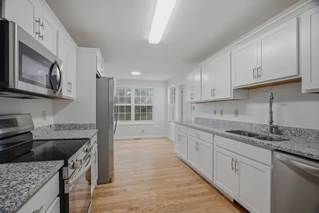 a kitchen with stainless steel appliances granite countertop a sink stove and cabinets
