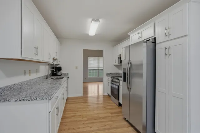 a kitchen with stainless steel appliances granite countertop a refrigerator and a sink