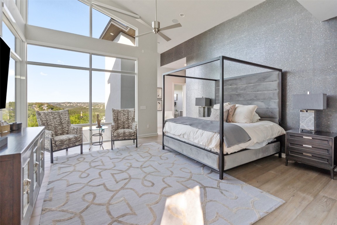 2551 Waymaker Way Austin, TX 78746 - Photo 14 of 36 a bedroom with a bed and large window with balcony view