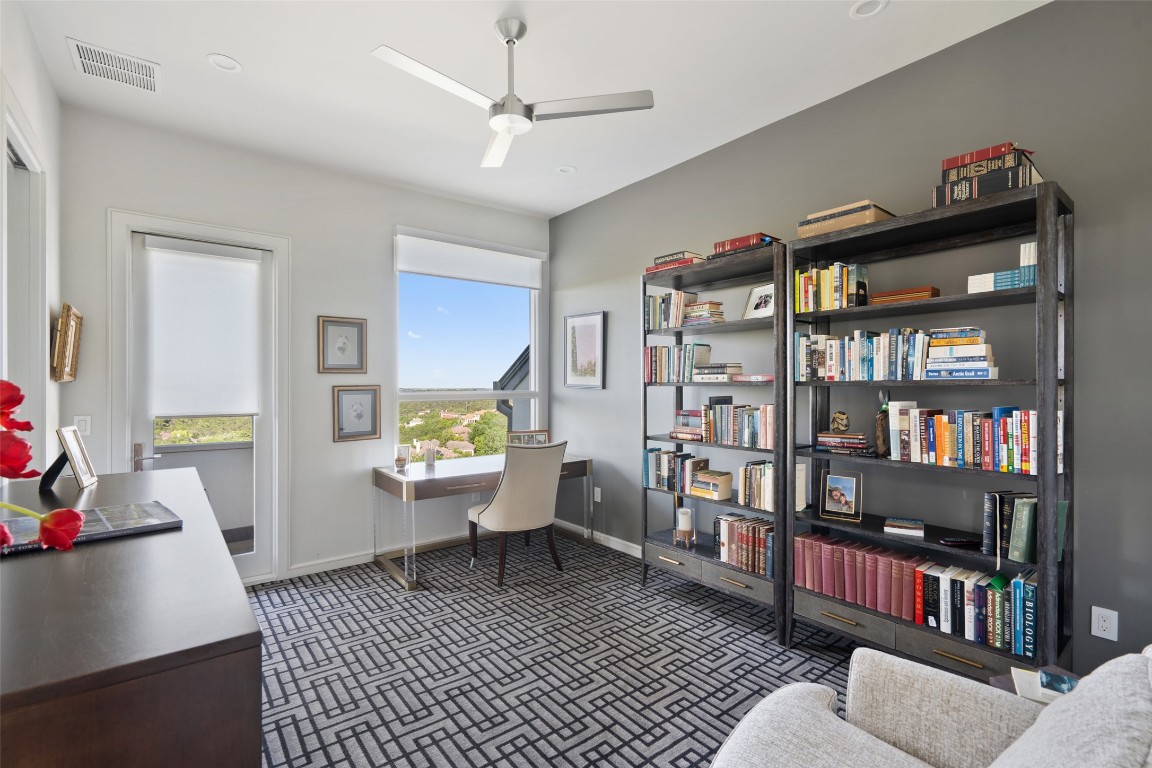 2551 Waymaker Way Austin, TX 78746 - Photo 23 of 36 a living room with furniture and a book shelf