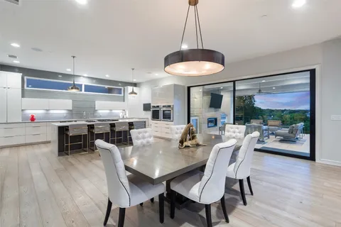 a kitchen with stove a sink and chairs
