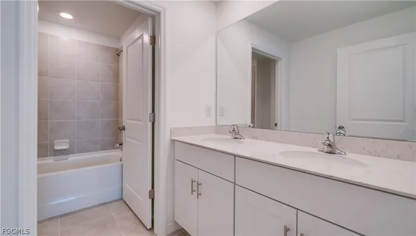a bathroom with a tub sink and mirror