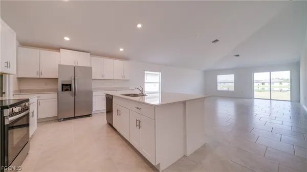 a kitchen with granite countertop white cabinets and stainless steel appliances