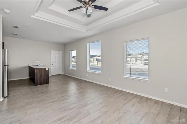 a view of an empty room with window and wooden floor