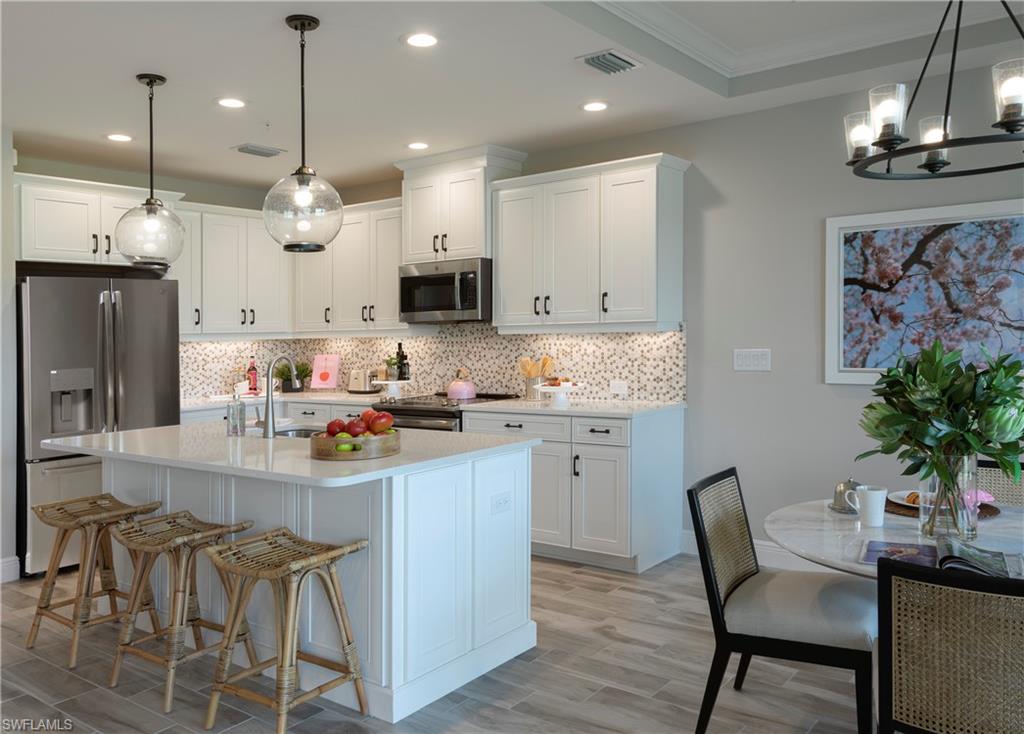 2665 Seychelles Circle, Unit 1902 Naples, FL 34112 - Photo 1 of 19 a kitchen with kitchen island granite countertop a sink and a refrigerator