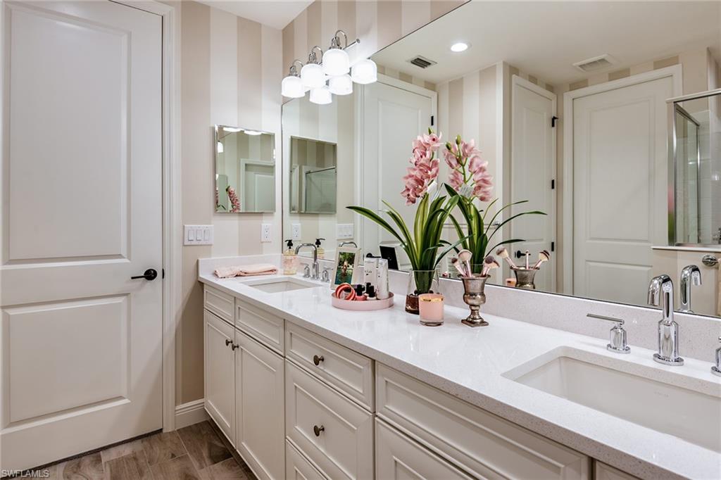 2665 Seychelles Circle, Unit 1902 Naples, FL 34112 - Photo 12 of 19 a bathroom with a double vanity sink and a mirror