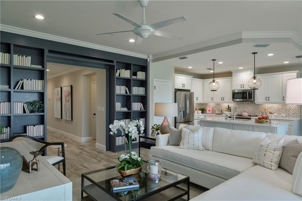 2665 Seychelles Circle, Unit 1902 Naples, FL 34112 - Photo 6 of 19 a living room with furniture kitchen area and a chandelier