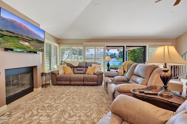 a living room with furniture fireplace and a large window