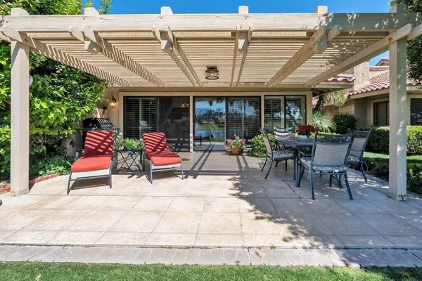 a view of a patio with a table chairs and backyard