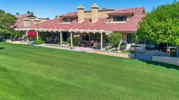 a view of an house with backyard and a tree