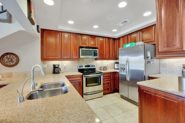 a kitchen with stainless steel appliances granite countertop a refrigerator sink and stove