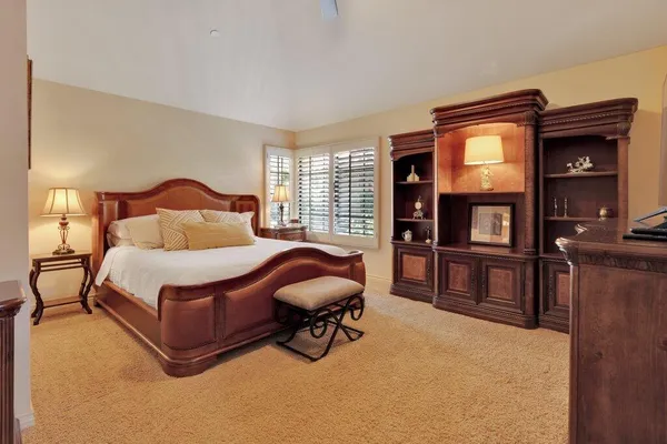 a bedroom with a bed and dresser with mirror