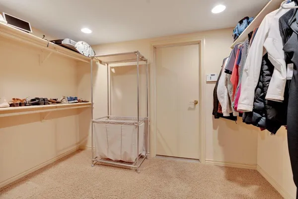 a view of walk in closet with clothes and shoes