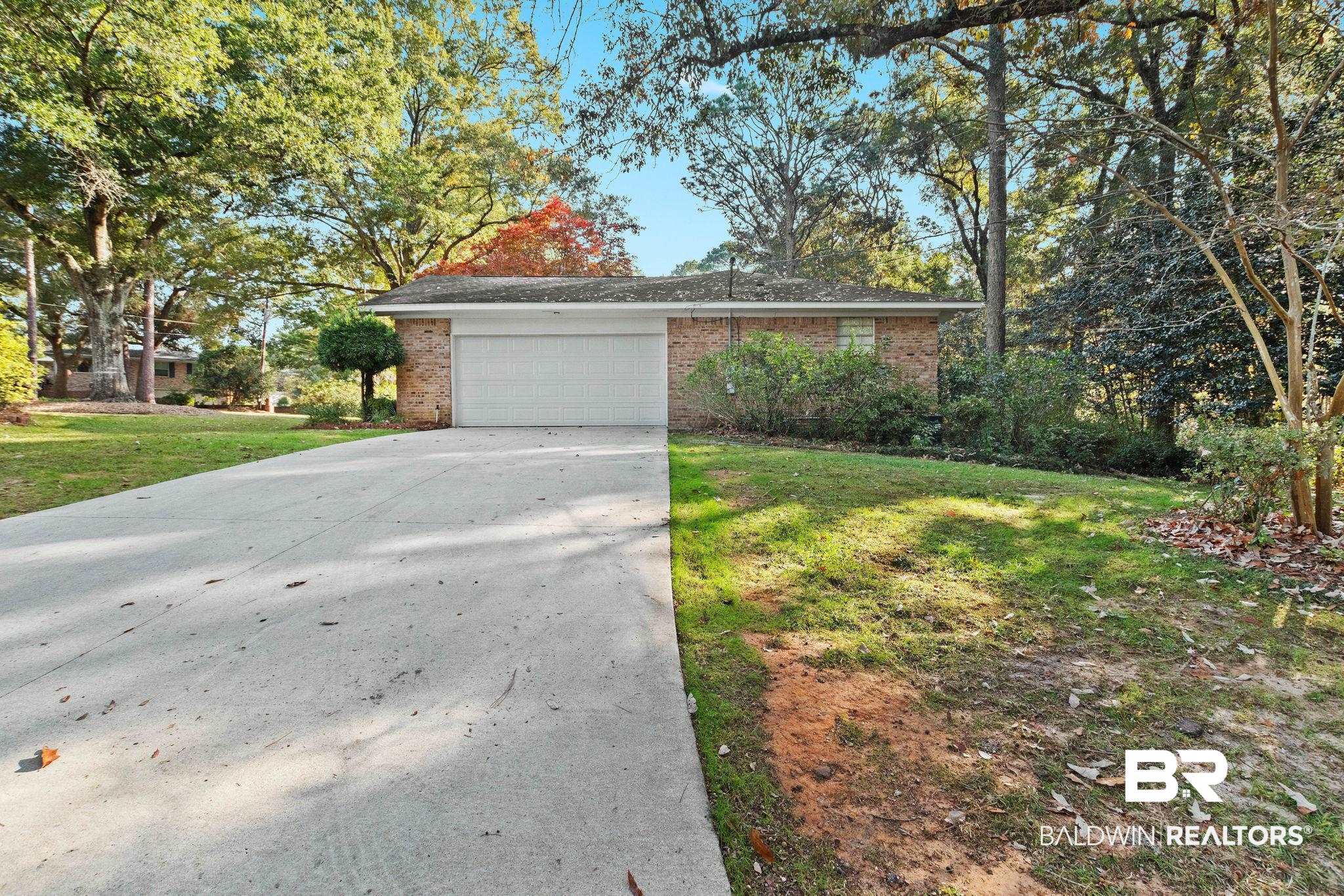 752 Evergreen Street Fairhope, AL 36532 - Photo 78 of 100 View of front of property featuring brick siding, driveway, a front yard, and a garage