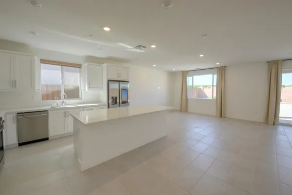 a large white kitchen with cabinets