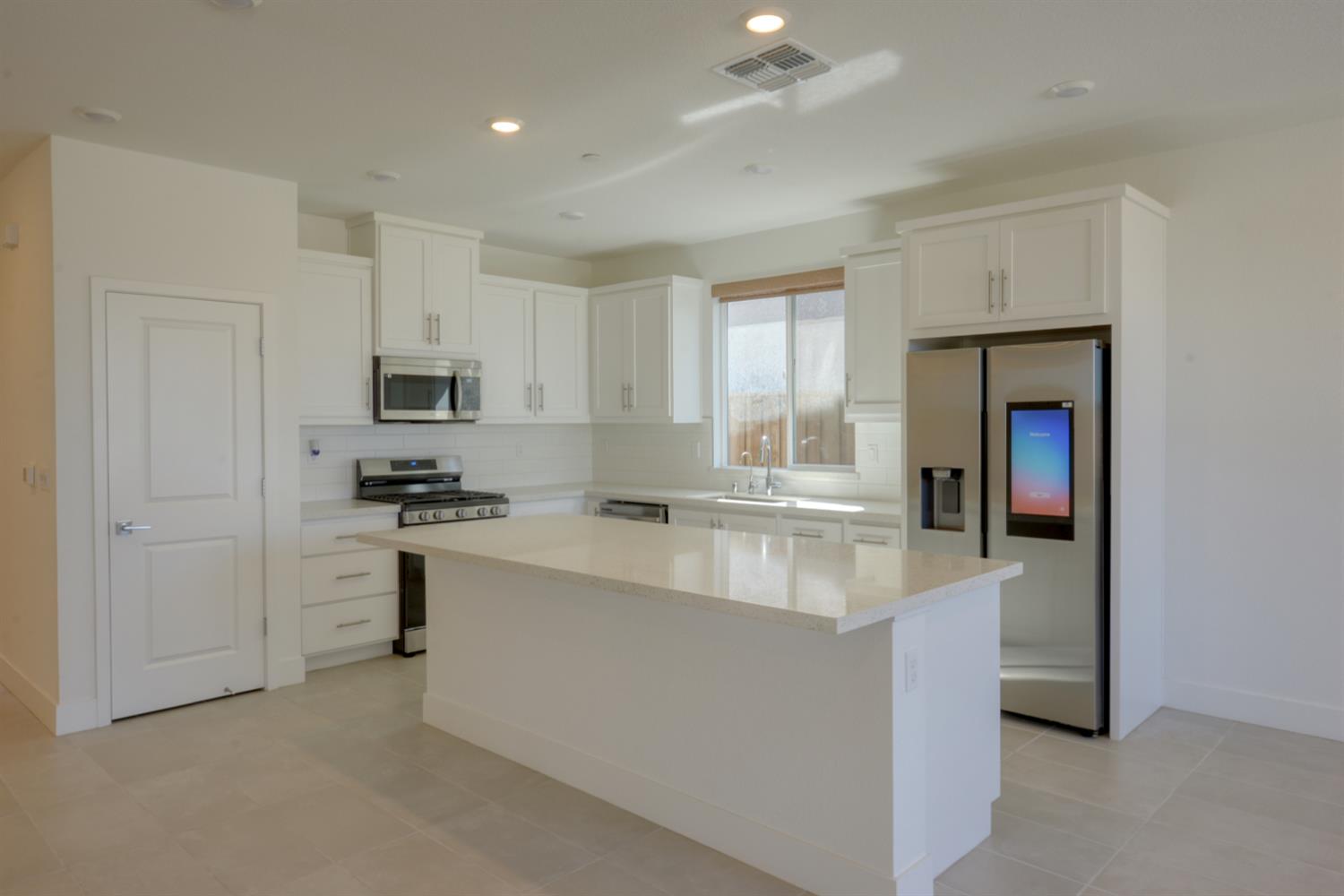 2109 Blossom Ranch Road Patterson, CA 95363 - Photo 13 of 33 a large white kitchen with cabinets