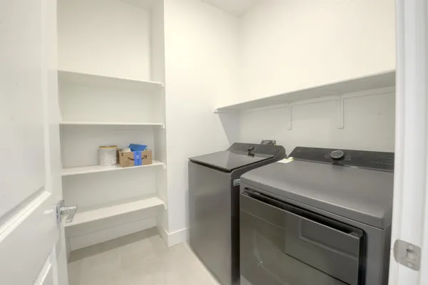 a view of kitchen with kitchen island white cabinets and refrigerator