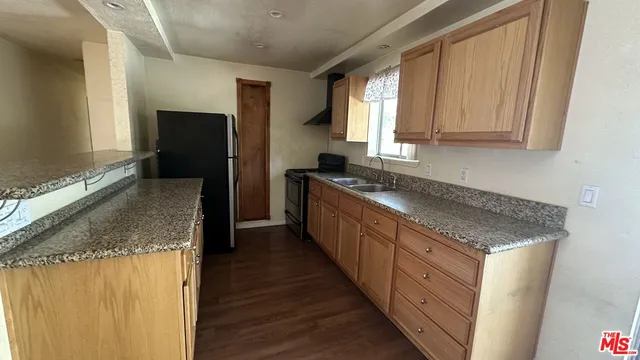 a kitchen with granite countertop a sink stove and refrigerator