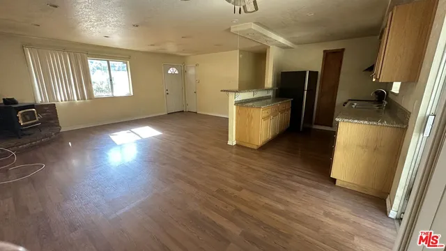 a view of a kitchen with fridge and wooden floor