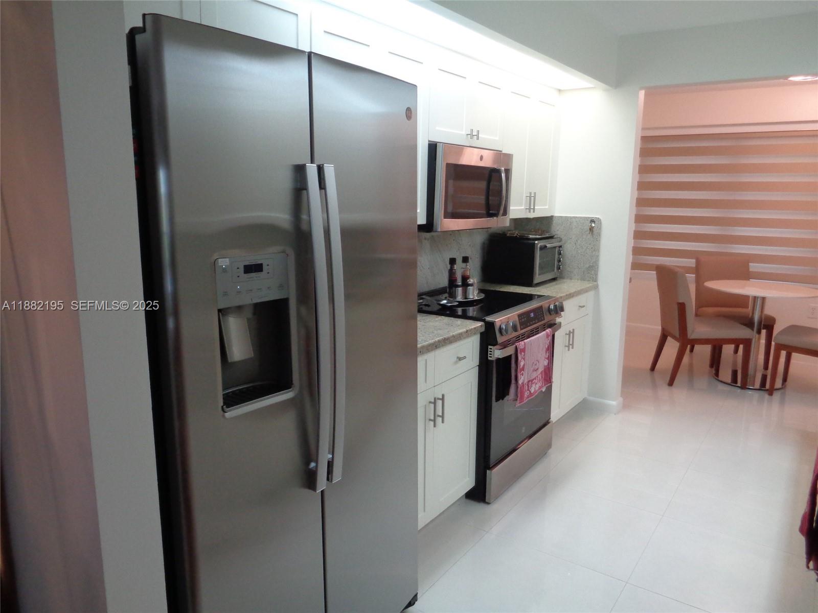 701 Southwest 141st Avenue, Unit 412R Pembroke Pines, FL 33027 - Photo 17 of 52 a kitchen with stainless steel appliances granite countertop a refrigerator and a stove top oven
