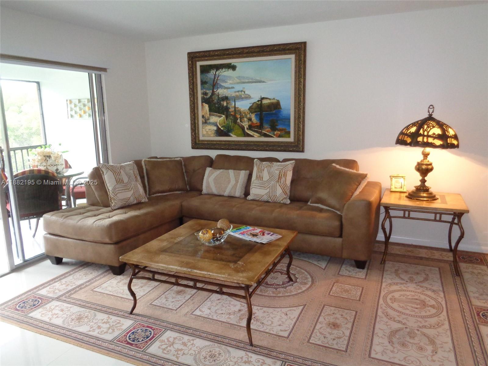701 Southwest 141st Avenue, Unit 412R Pembroke Pines, FL 33027 - Photo 23 of 52 a living room with furniture a rug and a window