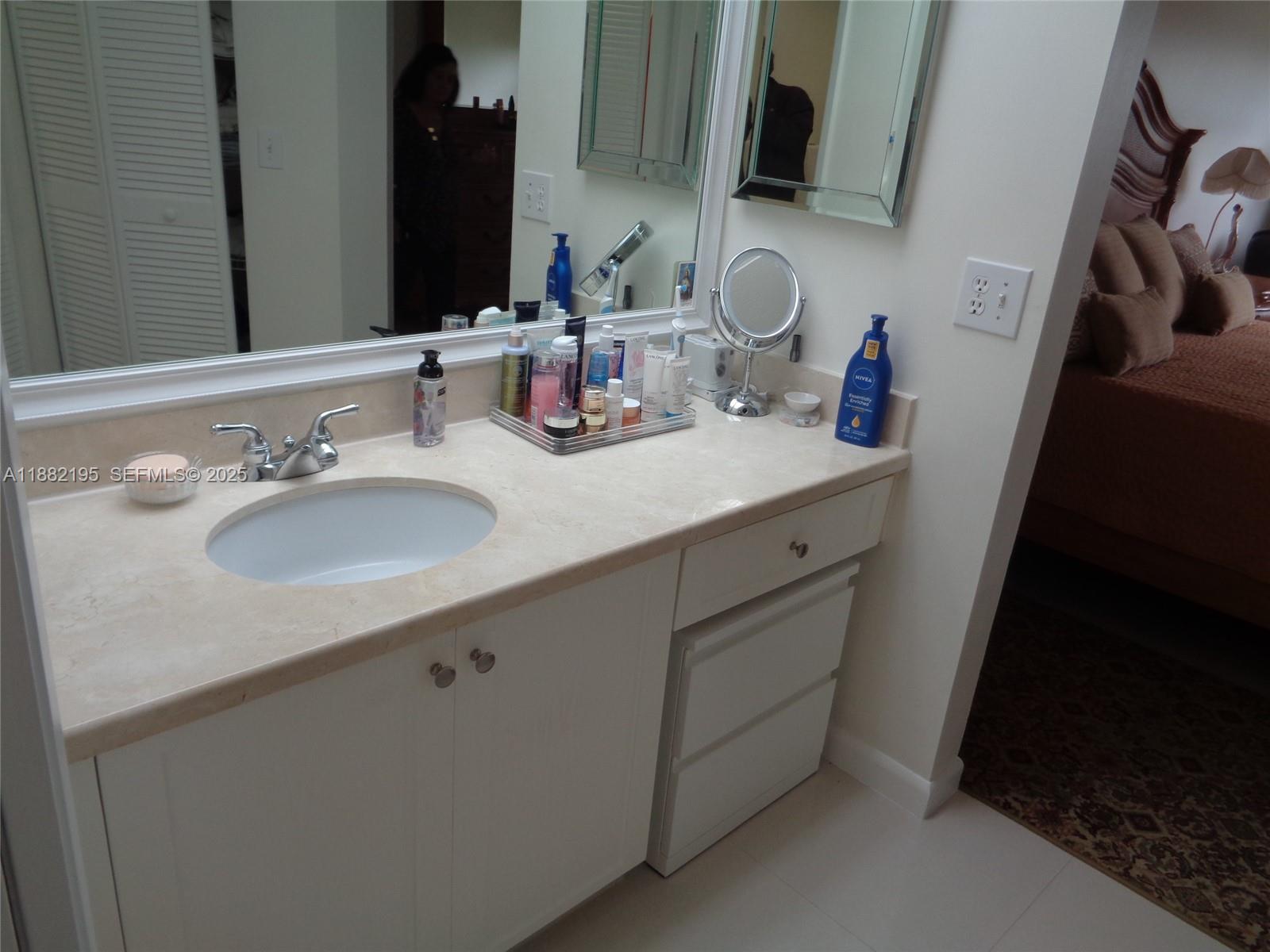 701 Southwest 141st Avenue, Unit 412R Pembroke Pines, FL 33027 - Photo 37 of 52 a bathroom with a sink and a mirror