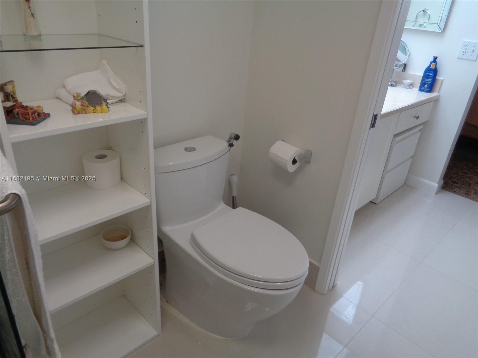 701 Southwest 141st Avenue, Unit 412R Pembroke Pines, FL 33027 - Photo 39 of 52 a white toilet sitting next to a bathroom sink and vanity