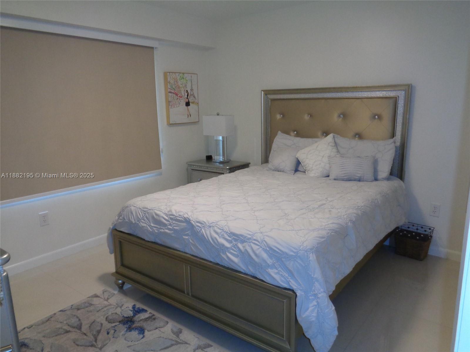 701 Southwest 141st Avenue, Unit 412R Pembroke Pines, FL 33027 - Photo 41 of 52 a bedroom with a bed and a night stand