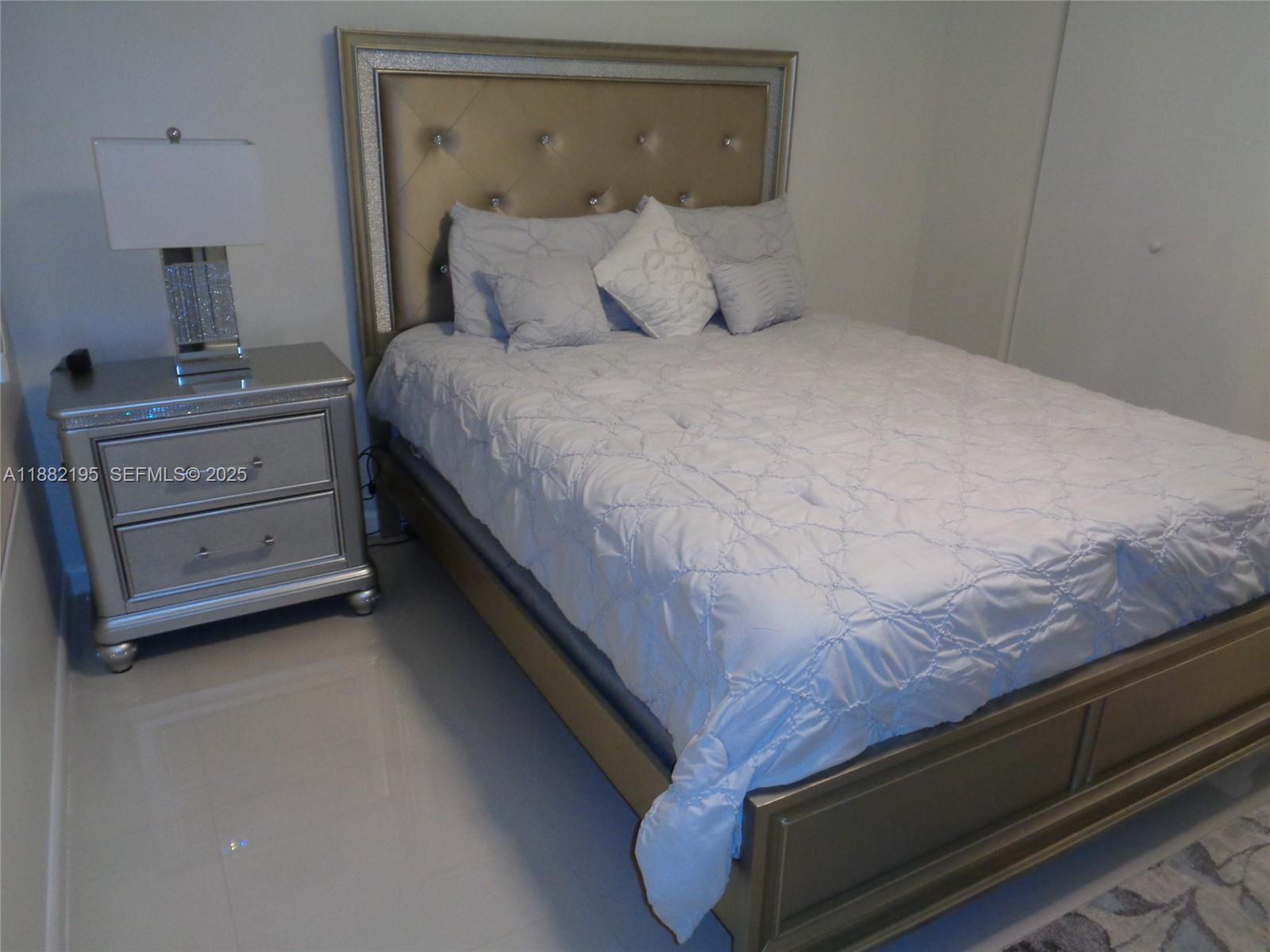 701 Southwest 141st Avenue, Unit 412R Pembroke Pines, FL 33027 - Photo 42 of 52 a large bed sitting in a bedroom next to a lamp