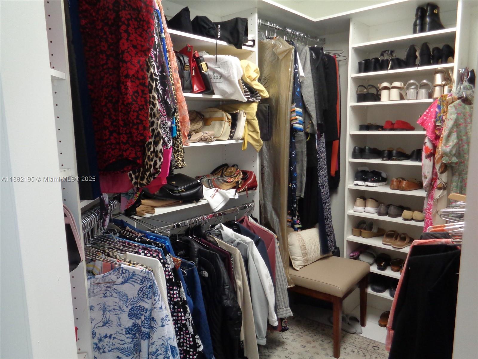 701 Southwest 141st Avenue, Unit 412R Pembroke Pines, FL 33027 - Photo 44 of 52 a view of walk in closet with clothes and shoes