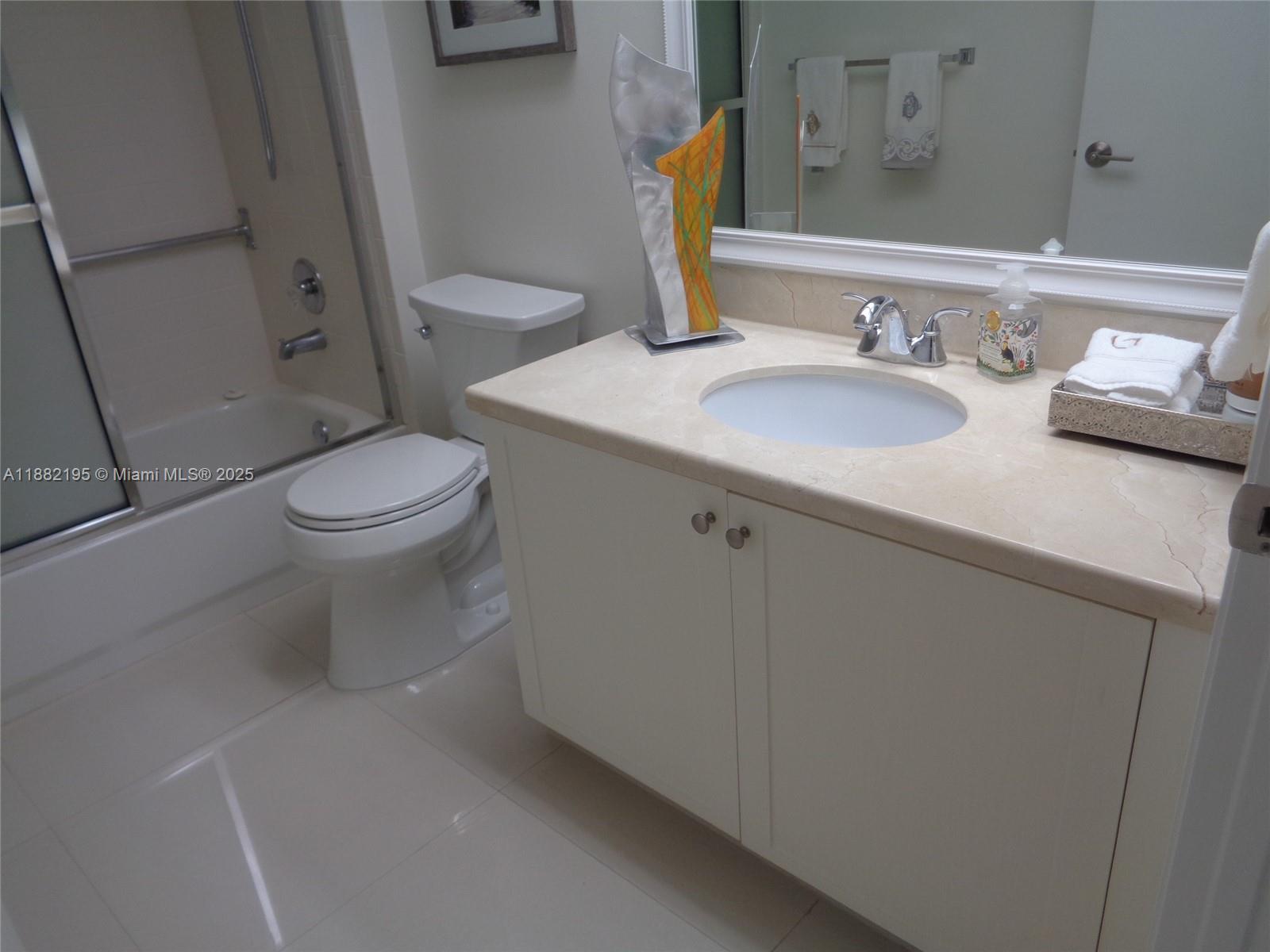 701 Southwest 141st Avenue, Unit 412R Pembroke Pines, FL 33027 - Photo 46 of 52 a bathroom with a granite countertop toilet sink and mirror